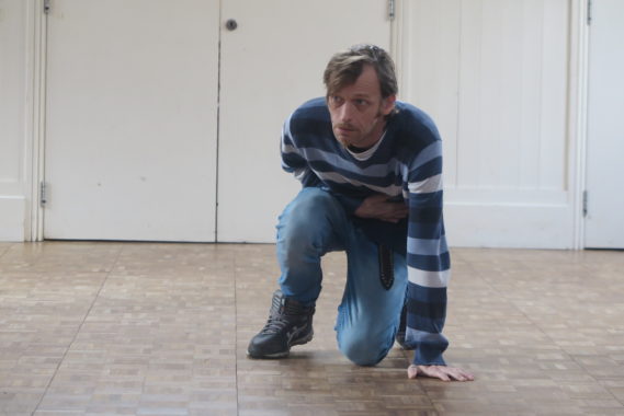 a man in blue crouched down in pain